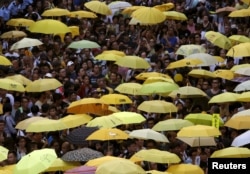 FILE - Pro-democracy protesters carrying yellow umbrellas, symbol of the Occupy Central civil disobedience movement, gather outside government headquarters in Hong Kong, China, Sept. 28, 2015.