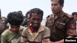 A member of Border Guards of Bangladesh comforts a Rohingya from Burma who was arrested while trying to get into Bangladesh, in Teknaf, June 18, 2012.