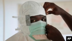 Seorang perawat memakai pakaian pelindung saat bersiap memasuki zona berisiko tinggi dari unit perawatan Ebola di Monrovia, Liberia (29/9).