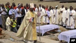 Clergymen gather around the coffins of the victims of the Christmas day bombing at St Theresa Catholic Church Madalla, during a mass funeral for the victims. Boko Haram claimed responsibility for the attack.