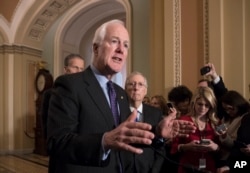 FILE - Senate Majority Whip John Cornyn, R-Texas, flanked by Sen. John Thune, R-S.D., left, and Senate Majority Leader Mitch McConnell, R-Ky., talks to reporters following weekly policy luncheons where they discussed school safety measures in response to the Parkland, Fla., assault that left 17 dead, at the Capitol in Washington, Feb. 27, 2018.