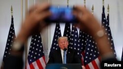 A reporter uses his mobile phone to record U.S. President Donald Trump at a news conference on the sidelines of the 73rd session of the United Nations General Assembly in New York, Sept. 26, 2018. 