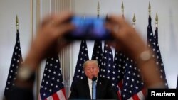 Seorang wartawan menggunakan ponselnya untuk merekam Presiden Donald Trump dalam konferensi pers di sela sidang Majelis Umum PBB di New York, 26 September 2018.