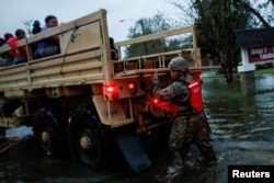 People are rescued by a member of the U.S. Army during the passing of Hurricane Florence in the town of New Bern, North Carolina, Sept. 14, 2018.