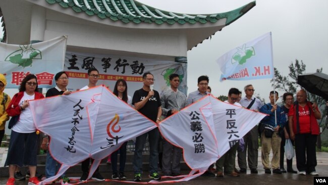 香港支联会副主席蔡耀昌（中间讲话者）及其成员5月5日冒雨举行六四风筝放飞行动 （美国之音记者申华拍摄）