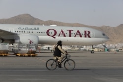 FILE - A Taliban soldier patrols on a bike in front of a Qatar Airways flight at the international airport in Kabul, Afghanistan, September 10, 2021. (West Asia News Agency via Reuters)