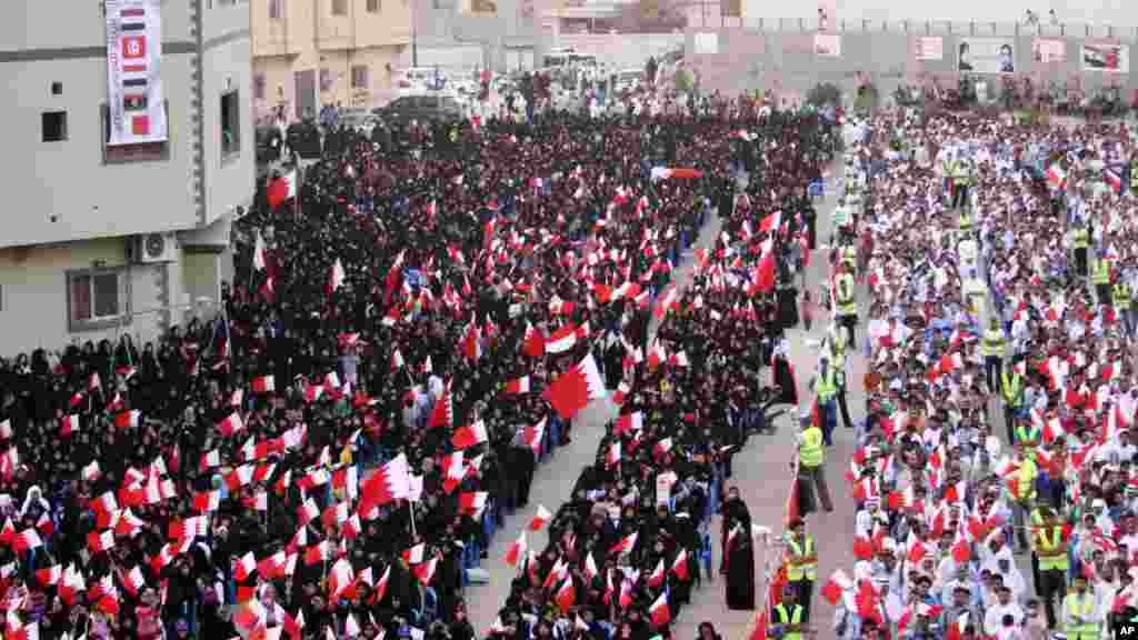 Des milliers de Bahreïnis agitent des drapeaux nationaux lors d'un rassemblement organisé par les partis d'opposition de Bahreïn exigeant la libération des prisonniers et de la démocratie à Maameer, Bahreïn, 21 octobre 2011.
