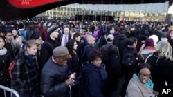 Commuters wait in a line to board busses into Manhattan in front of the Barclays Center in Brooklyn, New York, Nov. 1, 2012.