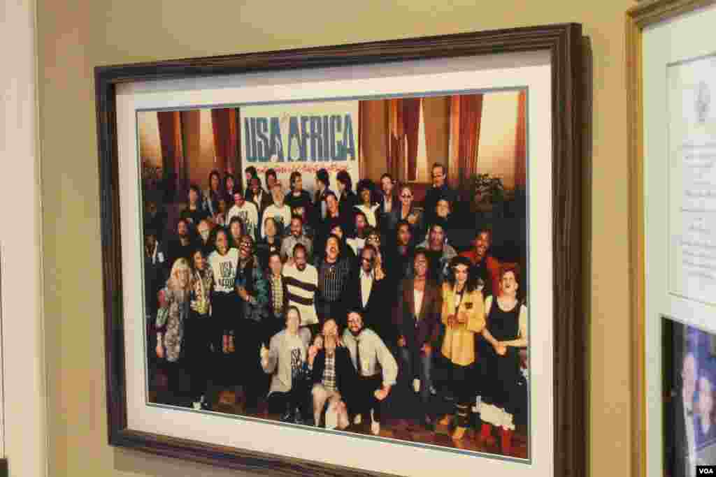 Une photo des stars américaine qui ont pris part à la chanson "Were are the World" affichée au bureau de Ken Kragen, l'initiateur de la chanson interviewé par l'envoyé spécial de la VOA Roger Muntu, à Hollywood, Los Angeles, le 20 février 2015.