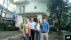 The Salwens in front of their smaller home after selling their mansion and donating half of the profits to charity.