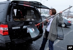 Kimberly Charles of Winston-Salem, North Carolina, loads a newly purchased snow shovel into her SUV after buying it at a hardware store in Winston-Salem, Jan. 20, 2016.