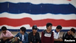 Cambodian migrant workers wait for document process as they prepare to migrate back to Cambodia at the Aranyaprathet Police station in Sa Kaew June 15, 2014. The International Organization for Migration (IOM) estimates that over the past week 100,000 Cambodians have poured over the border, as the military that seized power in a May 22 coup intensifies lax measures to regulate illegal labour. 