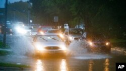 Los vehículos salpican al cruzar una zona inundada en Chimney Rock, al sur de Brays Bayou en Houston, el martes 17 de septiembre de 2019.