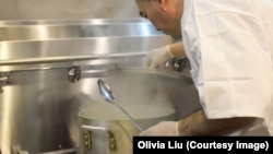 Chef Ekber Kayser removes the lid from the pot of Uyghur polo.