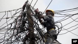 နိုင်ဂျီးရီးယားနိုင်ငံ၊ လာဂို့စ်မြို့တော်တွင် လျှပ်စစ်ဓာတ်အားလိုင်း ကို ပြင်ဆင်နေသည့် တာဝန်ရှိသူတဦး။ ဇူလိုင် ၂၂၊ ၂၀၁၂