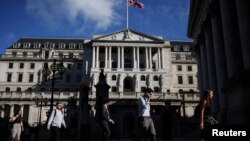 Personas pasan frente al Banco de Inglaterra durante la hora pico de la mañana, en Londres, el 29 de julio de 2021.