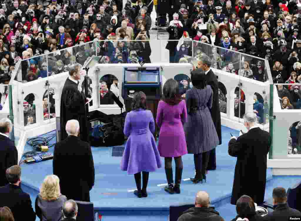 U.S. President Barack Obama (R) takes the oath from U.S. Supreme Court Justice John Roberts (L) as Obama's family looks on during swearing-in ceremonies on the West front of the U.S Capitol in Washington, January 21, 2013