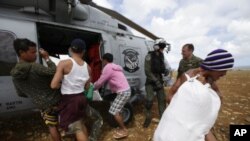 Un helicóptero estadounidense lleva suministros a los habitantes de un remoto poblado en una isla en Filipinas. 