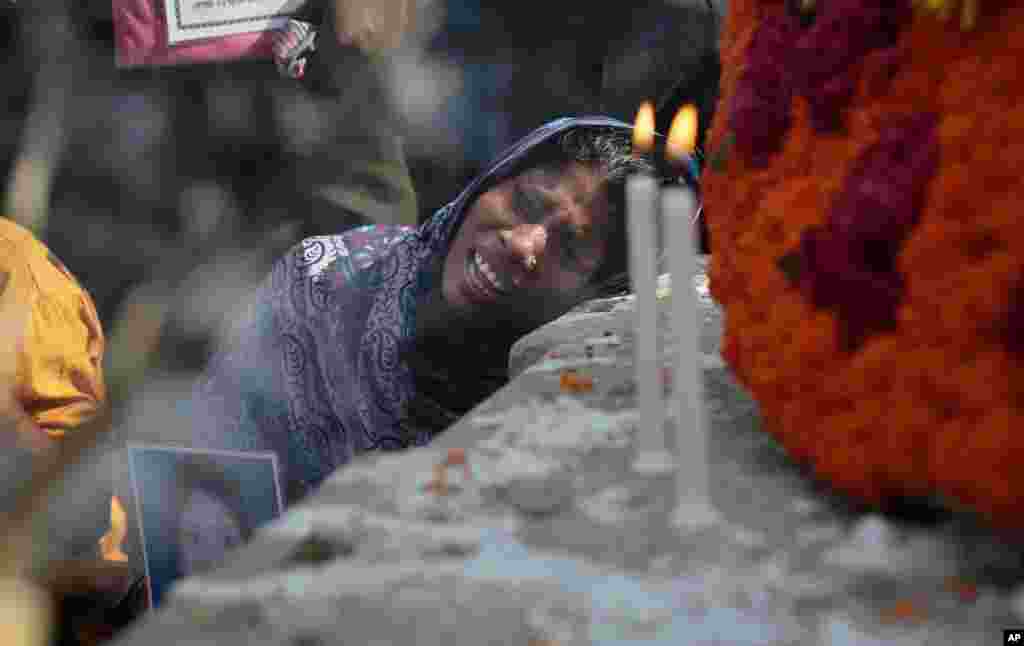 Một người thân của nạn nhân khóc trước một khu vực tưởng niệm được dựng lên để tưởng nhớ các nạn nhân trong vụ sập nhà ở Rana Plaza khi họ tề tựu về nơi này vào lần kỷ niệm thứ hai tại Savar, gần Dhaka, Bangladesh.