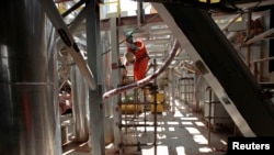 FILE - An employee works on a semi-submersible production platform for oil company Petrobras at the Brasfels shipyard in February 2011.