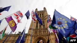 Bendera negara-negara anggota Uni Eropa dan bendera Inggris di depan gedung parlemen Iggris di London, 23 Oktober 2019. (Foto: dok).