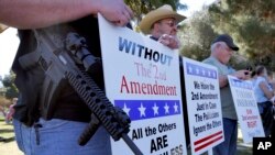 FILE - In this undated photo, gun rights supporters rally in Phoenix, Arizona. A U.S. appeals court on Thursday declared unconstitutional a federal law making it a crime for people under domestic violence restraining orders to own firearms.