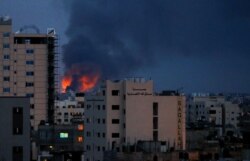 Asap dan api terlihat di atas gedung-gedung, di tengah meningkatnya pertempuran Israel-Palestina, di Gaza, 20 Mei 2021.