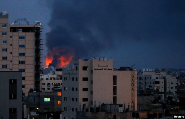 Asap dan api terlihat di atas gedung-gedung, di tengah meningkatnya pertempuran Israel-Palestina, di Gaza, 20 Mei 2021.