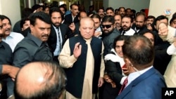 In this photo released by Pakistan Muslim League, Pakistani deposed Prime Minister Nawaz Sharif, center, arrives at an anti-corruption court in Islamabad, Pakistan, Tuesday, Sept. 26, 2017. 