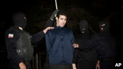 FILE - Iranian policemen prepare to hang a young convict in Tehran, Iran, Jan. 20, 2013. A new U.N. report says Iran has executed 73 minors in the past decade.