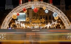 Seen through the windows of a moving tram, people take photos of a Christmas market, now closed due to the national COVID-19 lockdown, in Vienna, Austria, Nov. 23, 2021.