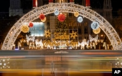 Seen through the windows of a moving tram, people take photos of a Christmas market, now closed due to the national COVID-19 lockdown, in Vienna, Austria, Nov. 23, 2021.