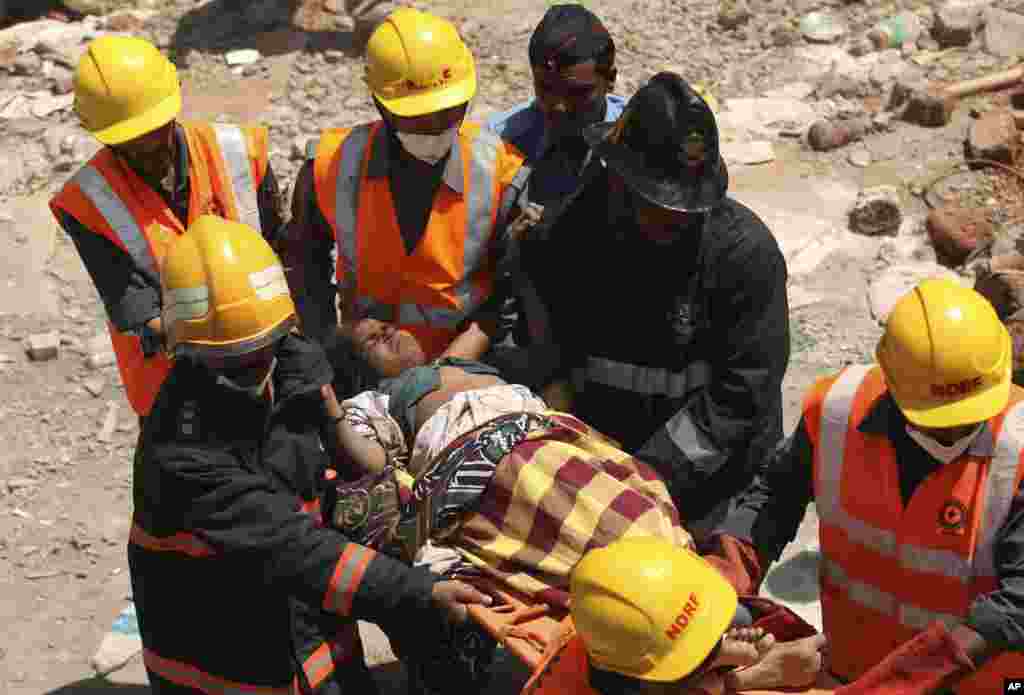 Nhân viên cứu hộ giúp một phụ nữ bị thương trong vụ tòa nhà sụp đổ.