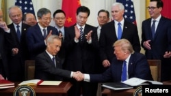 Donald Trump, président ya Etats-Unis atie manzaka na mokanda ya boyokani mpo na commerce (mombongo) na vice-Premier ministre chinois Liu He na Maison Blanche, Washington, 15 janvier 2020.