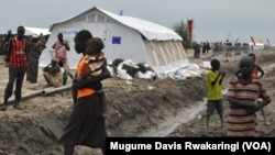 Children living at the UNMISS compound in Malakal hang around outdoors near a UNICEF tent. There are no schools at the UNMISS base, and the schools in town are shut.