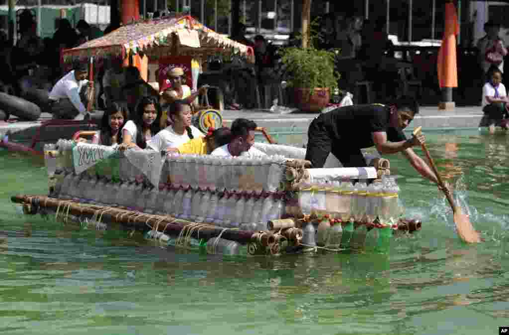 Warga Filipina mendayung perahu kecil yang dibuat dari botol-botol plastik bekas dan bahan daur ulang lainnya dalam sebuah lomba perahu di Manila, Filipina.