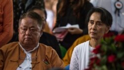 Myanmar's State Counselor Aung San Suu Kyi, right, and Win Htein, chief executive committee members of the National League for Democracy (NLD), attend the funeral service for the party's former chairman Aung Shwe in Yangon on Aug. 17, 2017.