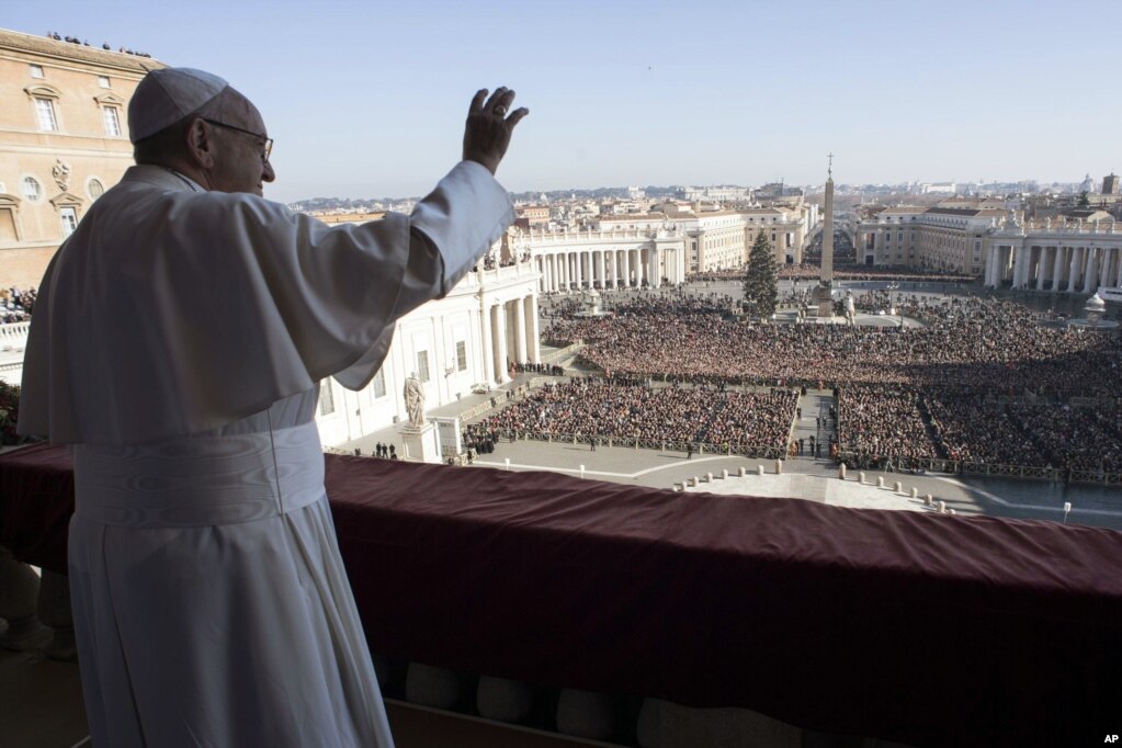 Pope Francis waves to faithful during the Urbi et Orbi (Latin for ' to the city and to the world') Christmas' day blessing from the main balcony of St. Peter's Basilica at the Vatican, Dec. 25, 2017. 