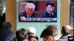 People watch a TV screen showing images of U.S. President Donald Trump, left, and North Korean leader Kim Jong Un at the Seoul Railway Station in Seoul, South Korea, Tuesday, Nov. 21, 2017. Trump announced Monday the U.S. is putting North Korea's "murderous regime" on America's terrorism blacklist, despite questions about Pyongyang's support for international attacks beyond the assassination of its leader's half brother in February. The signs read "UN sanctions and The blow is not big." (AP Photo/Ahn Young-joon)