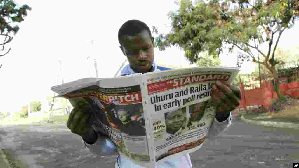 A Kenyan looks at a newspaper a day after the country's presidential election, at a roadside stall in Nairobi, Kenya, March 5, 2013.