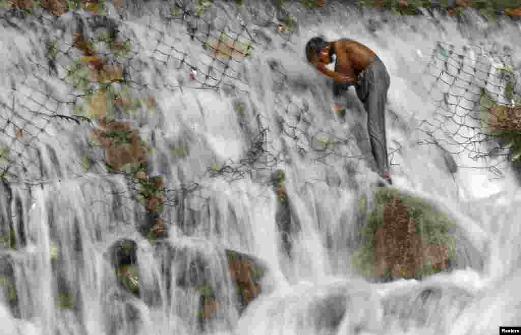 A boy bathes in a stream at Dara on the outskirts of Srinagar, India. 