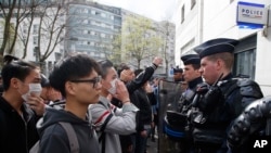 Des membres de la communauté chinoise sont confrontés à des policiers anti-émeutes lors d'une manifestation devant le commissariat du 19ème arrondissement, à Paris, le mardi 28 mars 2017.
