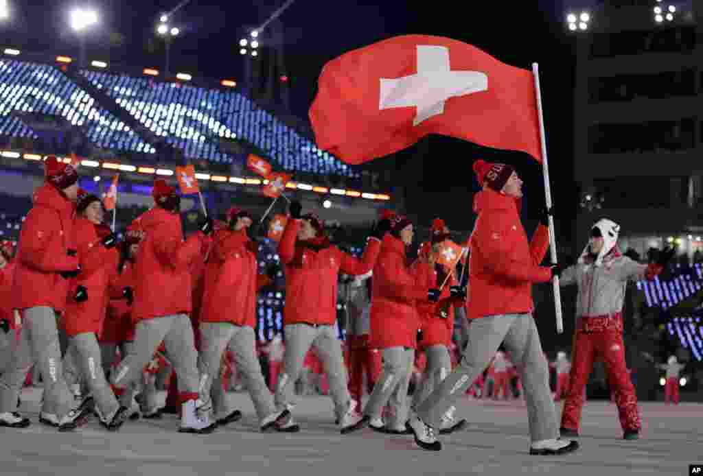 Dario Cologna holds up the flag of Switzerland during the opening ceremony of the 2018 Winter Olympics in Pyeongchang, South Korea, Feb. 9, 2018.