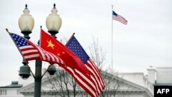 FILE - A lamp post is adorned with a Chinese national flag in between two U.S. flags in front of the White House in Washington, January 17, 2011. 