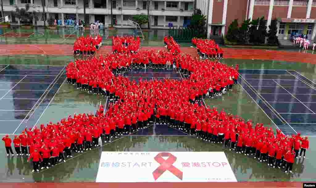 Students form a giant red ribbon during a publicity campaign to promote awareness about HIV/AIDS in Taipei, November 30, 2012. 