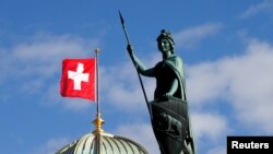 Patung Helvetia di depan Gedung Parlemen Swiss (Bundeshaus) di Bern, Swiss, 13 Maret 2020. (REUTERS / Denis Balibouse)
