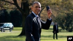 FILE - President Barack Obama holds up his Blackberry as he walks on the South Lawn of the White House in Washington.