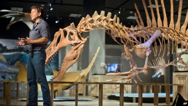 Los paleontólogos Paul C. Sereno frente a un modelo de un Spinosaurus