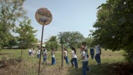 Children walk past a sign reading in Spanish 