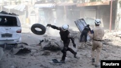 Civil defense members look for survivors after an airstrike on a rebel-held part of Aleppo, Syria, April 16, 2016. Syrian government forces, with some Russian support, seem to be massing combat power around the city.